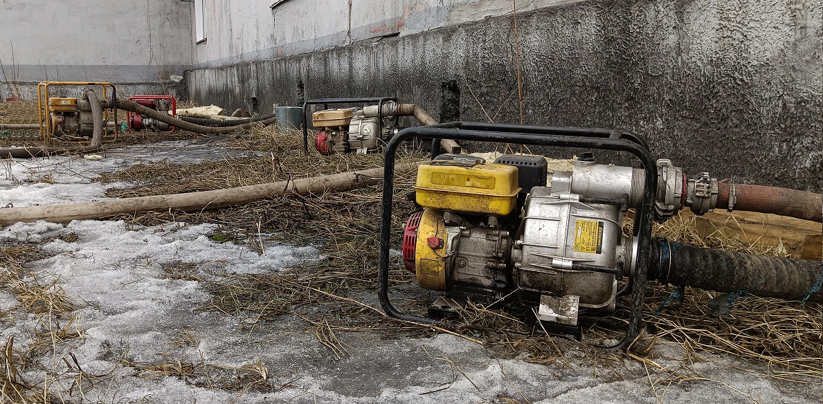 Откачка мотопомпами талой воды из подвала дома в Хабаровском крае